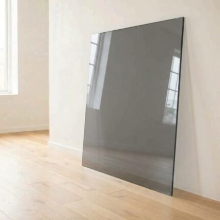 4mm grey tinted glass panel cut to size with polished edges, leaning against a white wall