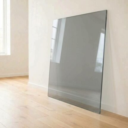 5mm grey tinted glass panel cut to size with polished edges, leaning against a white wall